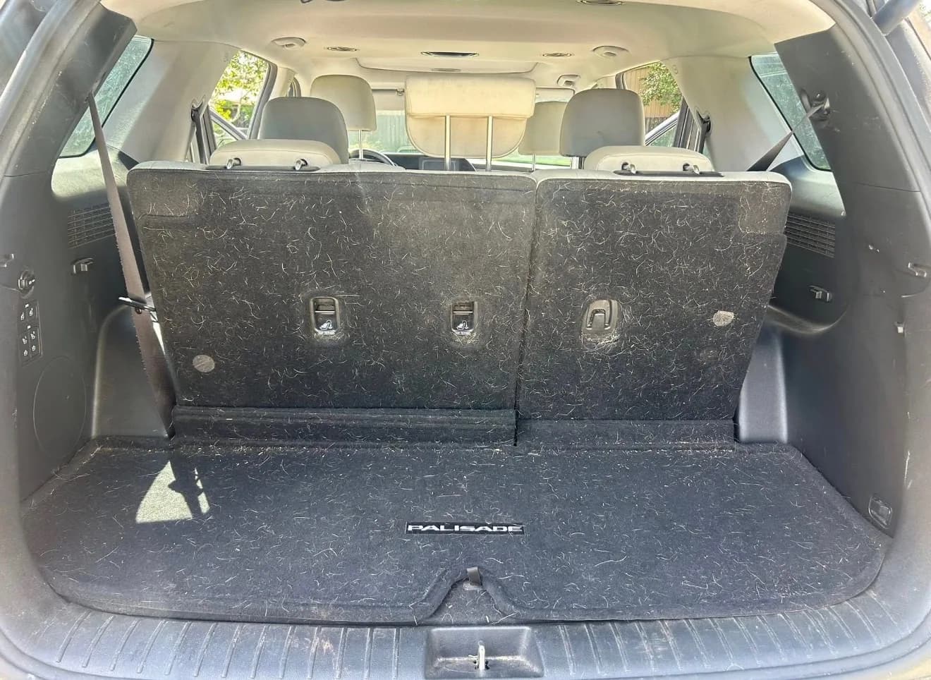 SUV cargo area with dirt and debris before an interior detail