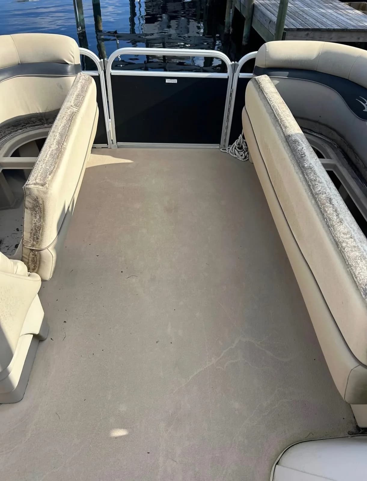 Pontoon boat deck and seats with dirt before cleaning
